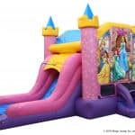 A colorful inflatable bounce house Long Island, NY featuring princess illustrations, two slides, and castle-like turrets with blue cone tops. The structure is mainly pink, purple, and yellow—perfect for party rentals Long Island.