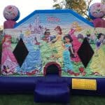 A colorful bounce house Long Island, decorated with Disney princesses like Cinderella, Belle, and Ariel, stands on grass in a backyard with trees and a fence—perfect for party rentals in Long Island, NY.