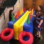 Two girls playing with an inflatable object from party rentals Long Island enjoy endless fun and laughter.