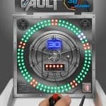 A hand holds a joystick in front of "The Vault," a party rentals Long Island game featuring a circular panel with colored LED lights, a digital timer at 30 seconds, and a vault-themed design.