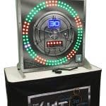 An arcade game machine called “The Vault” with a large circular light display, a digital timer showing 30 seconds, and game controls, set on a table with matching signage—perfect for party rentals Long Island or NY events.