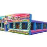 A large, colorful inflatable obstacle course designed to look like a candy shop, perfect for party rentals Long Island. It features bright decorations, candy patterns, and multiple entryways on a white background.