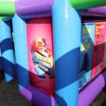Brightly colored inflatable structure with panels featuring various colorful designs and text, including mathematical and inspirational messages, set up outdoors on a black surface—ideal for NY events and bounce house Long Island party rentals.