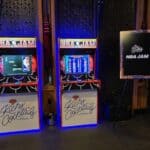 Two NBA Jam arcade machines are side by side, glowing with colorful displays. A large “NBA JAM” sign stands out in this vibrant NY indoor entertainment venue—perfect for party rentals Long Island style.