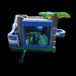 The 7 in 1 Tropical Combo features a blue and green inflatable bounce house with palm tree corners and an attached slide, perfect for party rentals on Long Island—shown isolated against a black background.