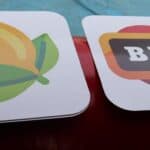 Two square signs: one with a stylized yellow lemon with green leaves, the other with a rectangular bar symbol featuring "BAR" in white letters on a dark background—perfect decor for party rentals Long Island, NY or bounce house Long Island events.