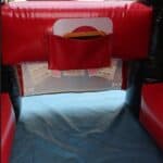 A close-up of a red and black bounce house Long Island, NY, shows a pocket holding a card and a translucent panel with reversed "BAR" signs from a slot machine design. Blue flooring is visible underneath, perfect for party rentals Long Island celebrations.
