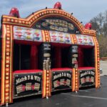 An inflatable carnival game designed like a jumbo slot machine with three play stations, colorful lights, and signs reading “Match 3 & Win” and “Jumbo Slot.” Perfect for party rentals Long Island events and set up outdoors on a black mat.
