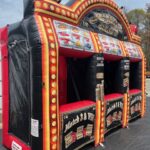Inflatable casino-themed game booth with slot machine graphics, red and yellow lights, and three separate "Match 3 & Win!" sections set up outdoors on a black mat—perfect for party rentals Long Island events.