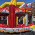 A colorful inflatable bounce house Long Island, themed to look like a volcano with red and yellow lava designs and "FLOOR IS LAVA" written on it, set outdoors on a sunny day—perfect for your next party!.