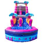 An inflatable water slide with vibrant pink, blue, and purple colors, featuring palm tree decorations and a small pool at the base. A central ladder leads to two slides that end in the pool.